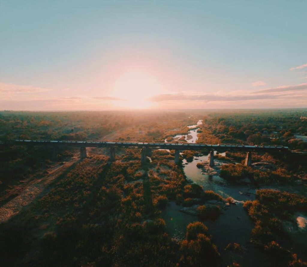 Kruger Shalatis tåg på Selatibron, sett från luften, ovanför floden och bushen, med solen lågt vid horisonten