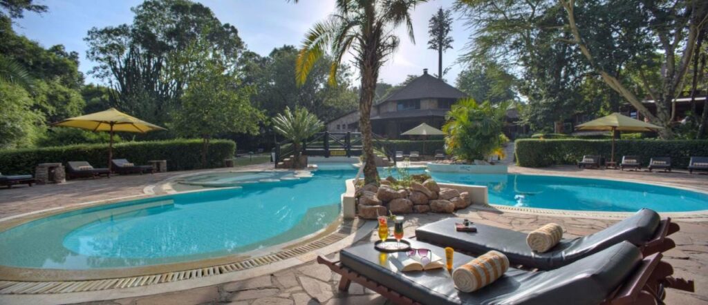 Den lagunformade poolen på Sarova Mara Game Camp, runt en liten klippö med en palm