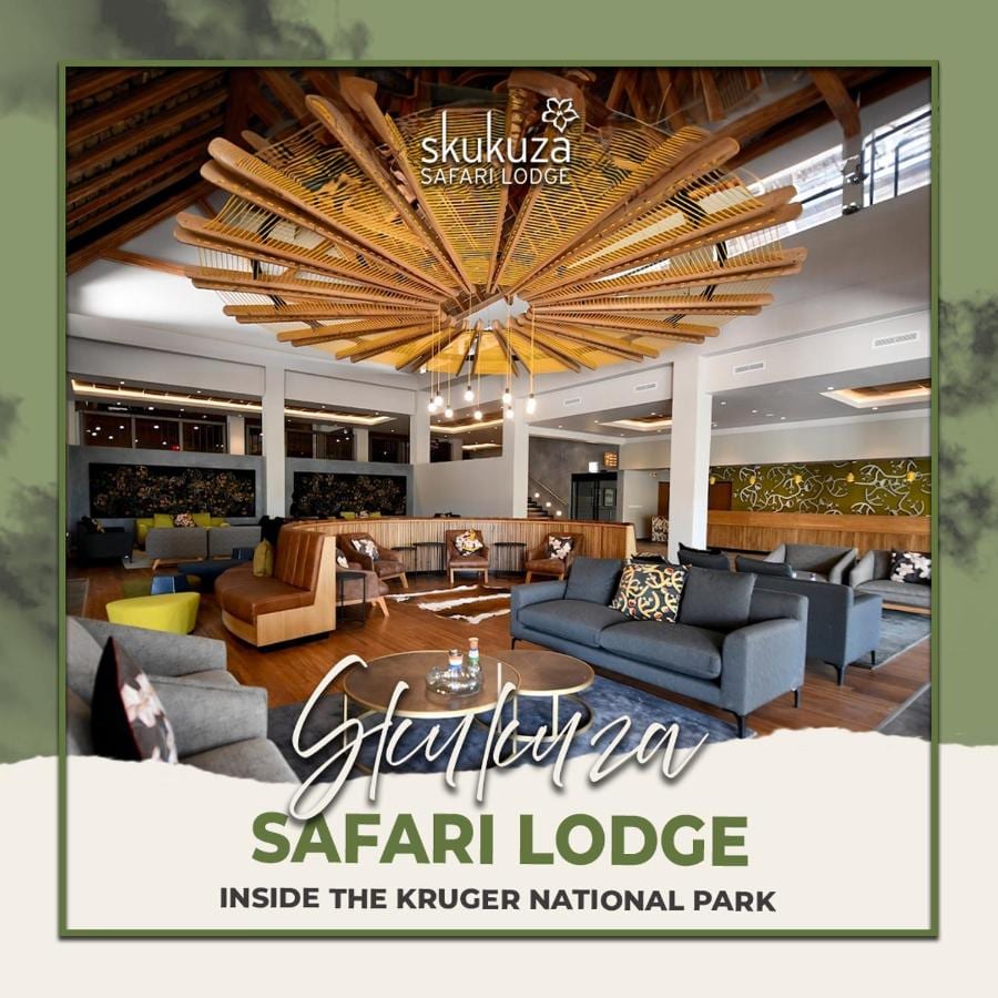 Loungen i lobbyn på Skukuza Safari Lodge under ett stjärnformat tak av träribbor, med lodgens namn skrivet ovanpå