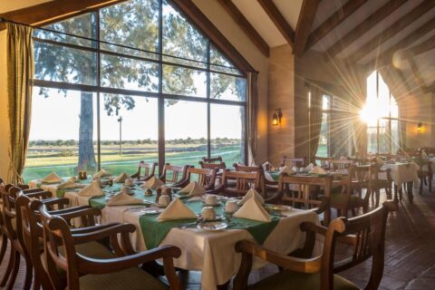 Restaurangen på Sweetwaters Serena Camp, med dukade bord framför ett stort fönsterparti mot slätten